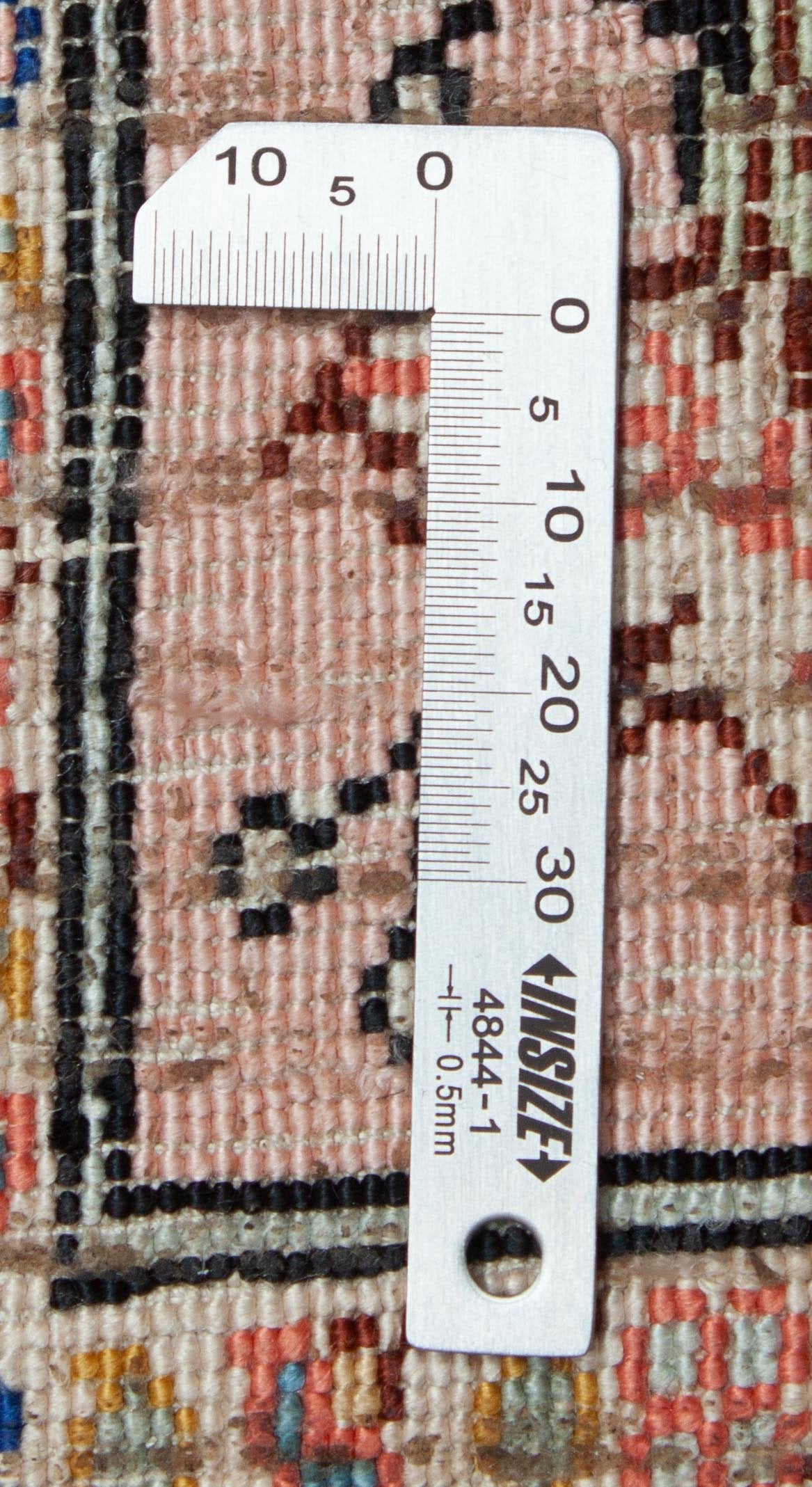 Eine Fotoaufnahme eines Hereke Teppichs.