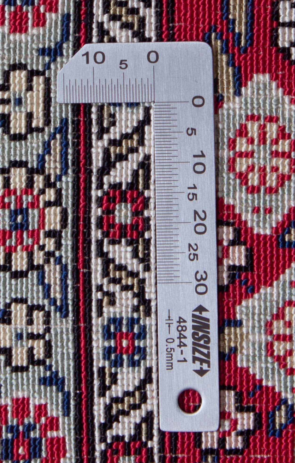 Eine Fotoaufnahme eines Hereke Teppichs.