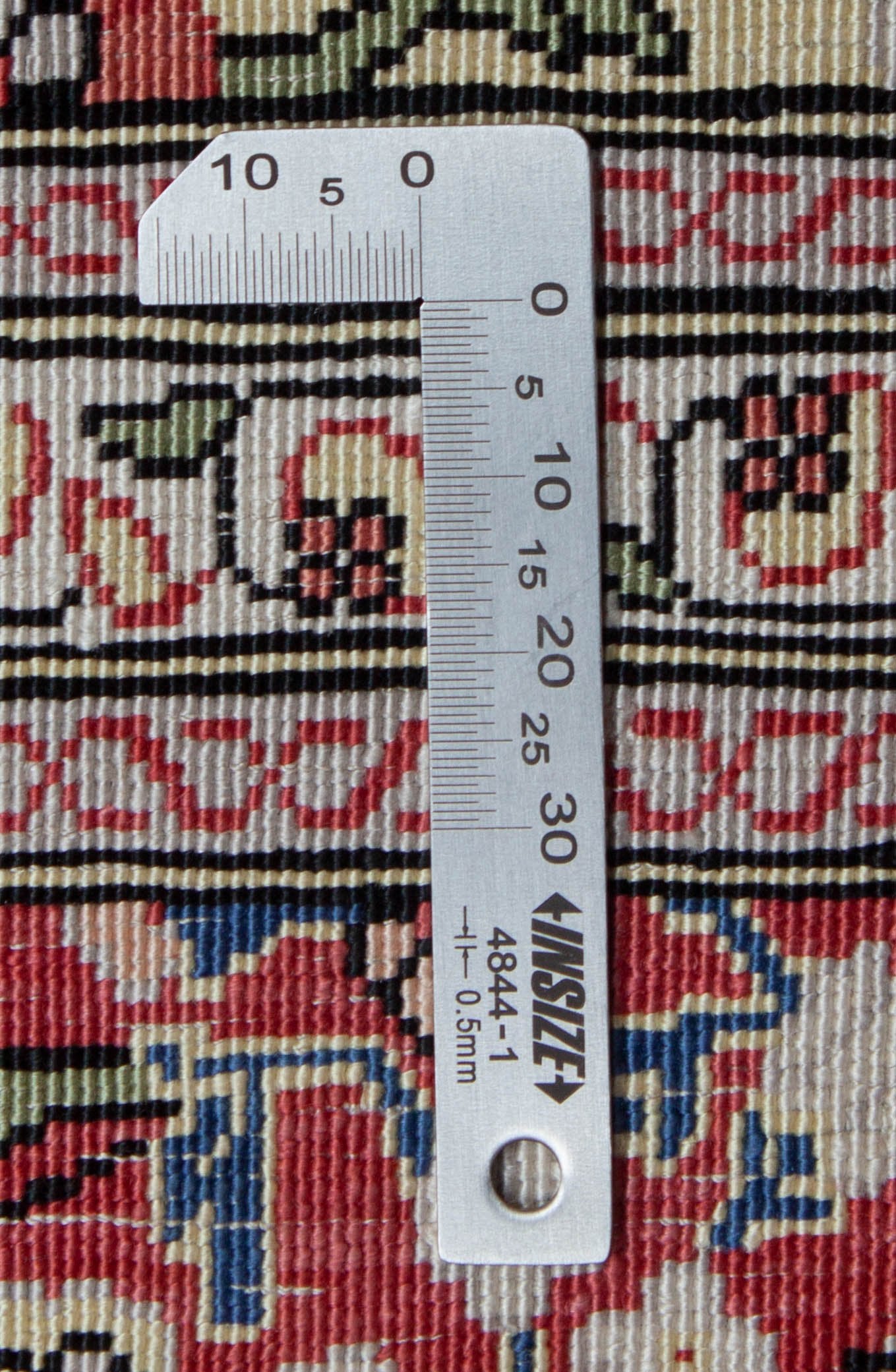 Eine Fotoaufnahme eines Hereke Teppichs.