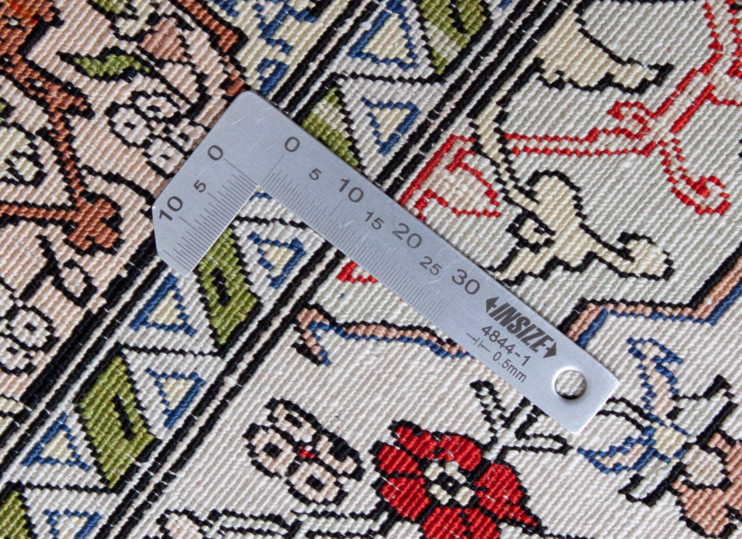 Eine Fotoaufnahme eines Hereke Teppichs.