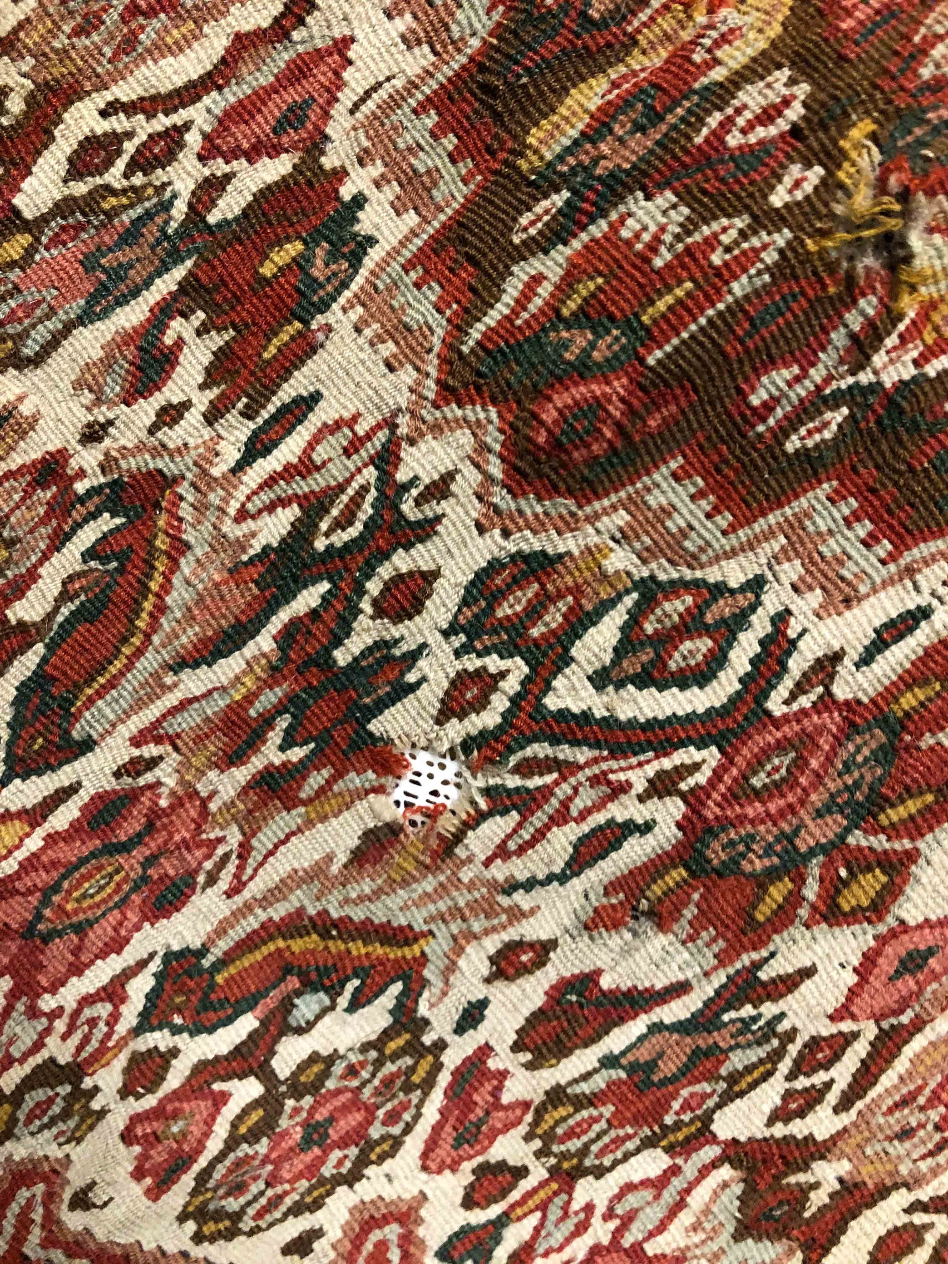 Eine Fotoaufnahme eines Senneh Kelim Teppichs.